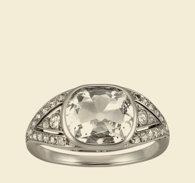 Ring, cushion-cut diamond in a bezel setting, shoulders pavé-set with diamonds